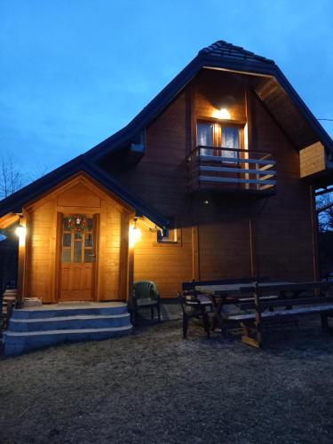 a log cabin with a porch and a balcony at Brvnare Na Brdu in Šljivovica