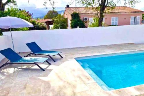 eine Terrasse mit 2 Stühlen, einem Sonnenschirm und einem Pool in der Unterkunft "Villa Querciu" Villa neuve & piscine privée in Prunelli-di-Fiumorbo