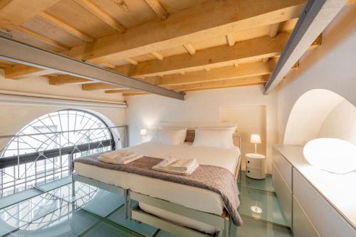 Un dormitorio con una cama en una habitación con ventana. en Milan Royal Suites - Centro Brera, en Milán