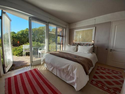 a bedroom with a large bed and a balcony at Absolute Beach Accommodation in Stompneusbaai