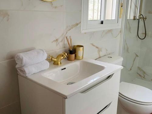 uma casa de banho branca com um lavatório e um WC em Exclusive House with Incredible Mountain Views em Alcaucín