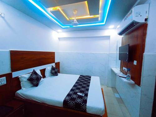 a bedroom with a bed with a blue light at HOTEL ASHADEEP in Ahmedabad