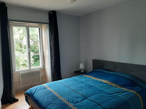 Un dormitorio con una cama azul y una ventana en Maison en Vendée avec Piscine, en Corpe
