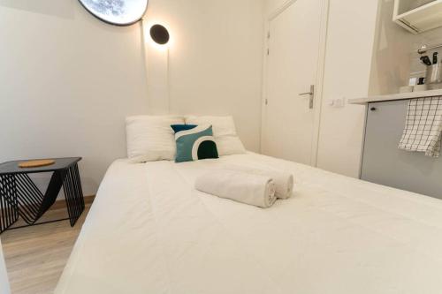 une chambre avec un grand lit blanc avec des oreillers dans l'établissement AG 4 Calif 4 galaxie, à Nice