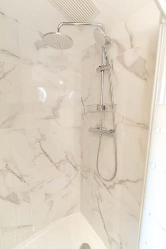 La salle de bains est pourvue d'une douche en marbre blanc. dans l'établissement AG 4 Calif 4 galaxie, à Nice
