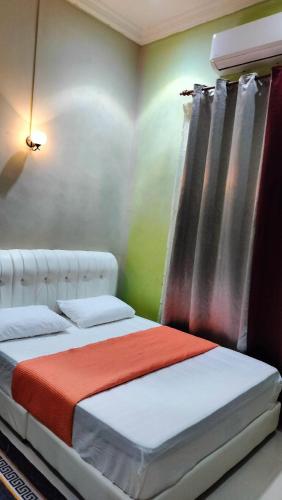 a bedroom with two beds and a window at ZR Homestay in Jitra