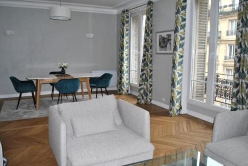 un salon avec un canapé, une table et des chaises dans l'établissement Appartement de 80 m² proche Gare du Nord, à Paris