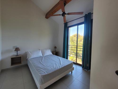 a bedroom with a bed and a large window at Villas au brusc près de la plage in Six-Fours-les-Plages