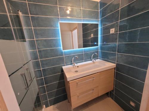 une salle de bain avec un lavabo et un miroir dans l'établissement Villas près de la plage, à Six-Fours-les-Plages