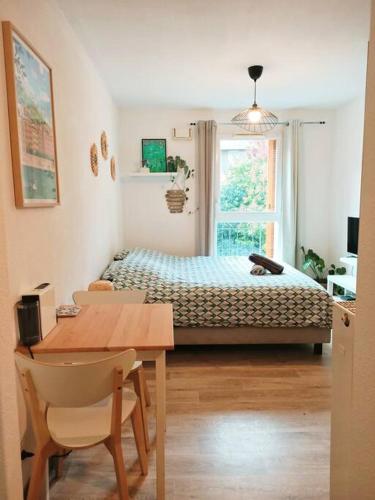 une chambre avec un lit et une table et une salle à manger dans l'établissement Beau studio calme proche Part-Dieu et centre Lyon, à Villeurbanne