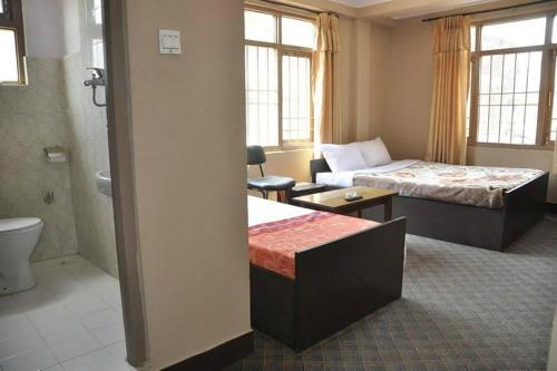 um quarto de hotel com duas camas e uma casa de banho em International Hotel Appt em Kathmandu