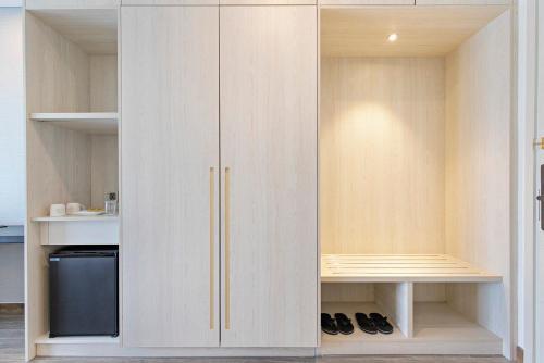 a closet with white cabinets and a black refrigerator at Danang Bay View Apartment - Phòng Code chủ in Da Nang