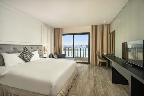 a hotel room with a large bed and a television at Danang Bay View Apartment - Phòng Code chủ in Danang