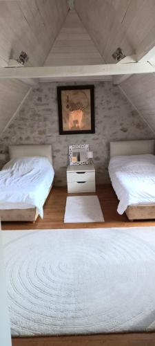 - une chambre mansardée avec 2 lits et une table de nuit dans l'établissement maison de campagne avec piscine, à Béduer