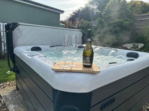 a bottle of wine and glasses in a hot tub at NORTHRISE RETREAT in Hastings