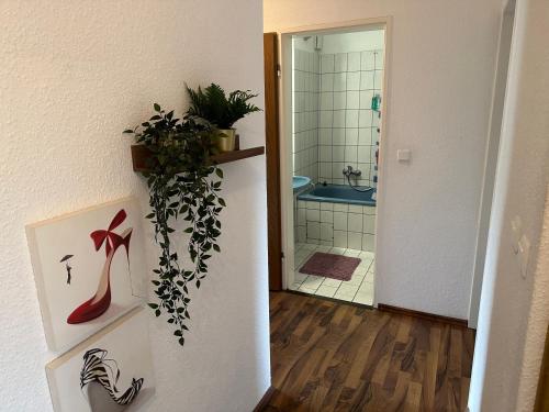 um corredor com uma casa de banho com um chuveiro e uma planta em Bremen Ferienwohnung em Bremen