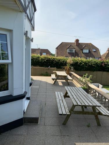 three wooden benches sitting outside of a building at NORTHRISE RETREAT in Hastings