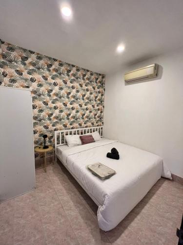 a bedroom with a white bed and a wall at Casa Cactus in Bangrak Beach