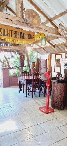 a dining room with a table and chairs and a sign at Garden House INChiangrai in Chiang Rai
