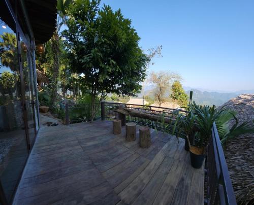 a wooden deck with benches and a view of the mountains at Pu Luong Paradise in Hương Bá Thước