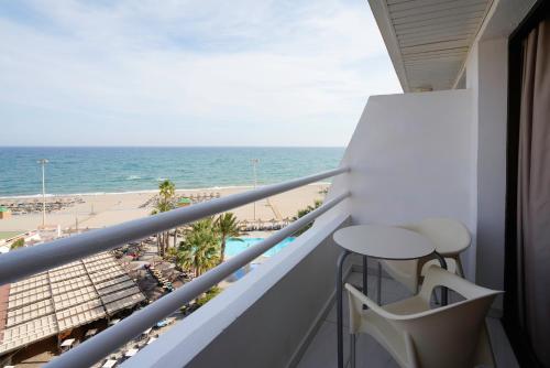 balcón con mesa y vistas a la playa en Alua Golf Trinidad, en Roquetas de Mar