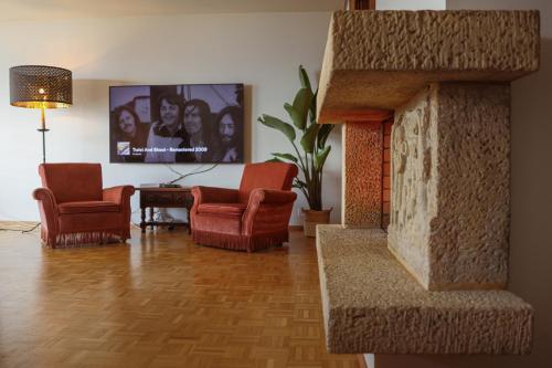 a living room with two chairs and a fireplace at Mountain View Apartment with Parking & Fast WiFi in Crans-Montana