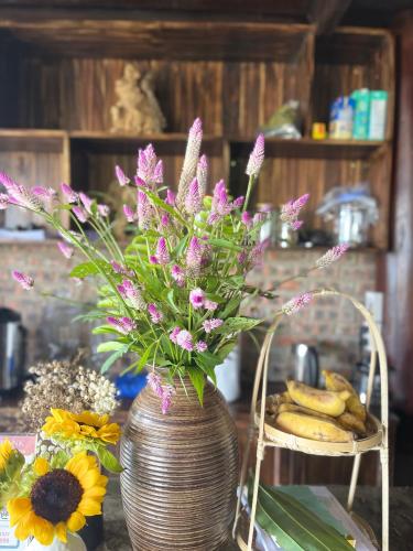 a vase with flowers in it on a table at Pu Luong Paradise in Hương Bá Thước