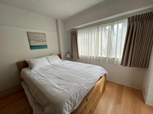 Un dormitorio con una cama grande y una ventana en Rhodes Kagurazaka - Vacation STAY 77350v en Tokio