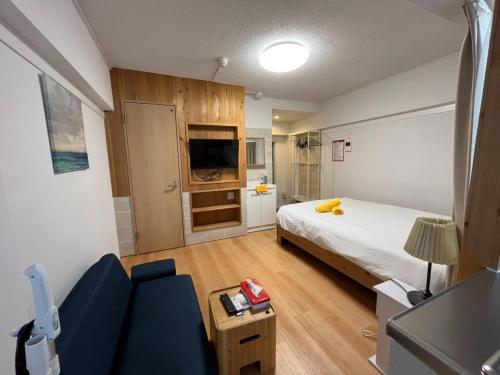 Habitación con cama, sofá y TV. en Rhodes Kagurazaka - Vacation STAY 77347v, en Tokio