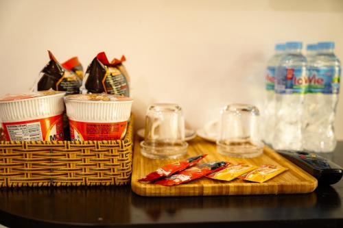a wooden cutting board with food and glasses on a table at Eva Măng Đen Homestay in Kon Von Kla