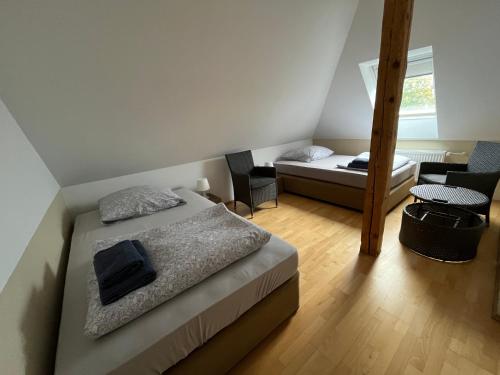 1 dormitorio pequeño con 1 cama y 1 silla en MWM-Pension-Hotel en Meine