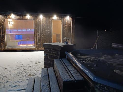 a room with a hot tub and a building with lights at Motylowe Wzgórze Apartamenty Zawóz in Zawóz