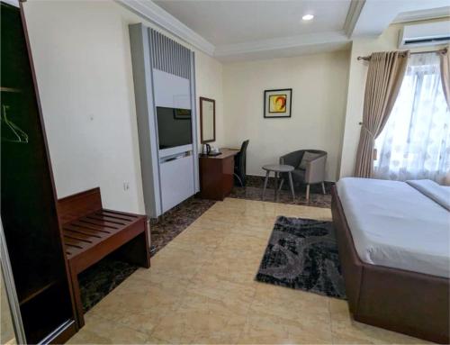 a bedroom with a bed and a tv and a couch at Newton Park Hotels Annex in Abuja