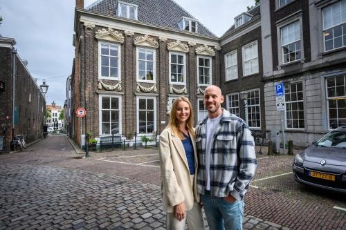 um homem e uma mulher em pé em frente a um edifício em B&B Cleyn Cruysenborgh 1531 em Dordrecht