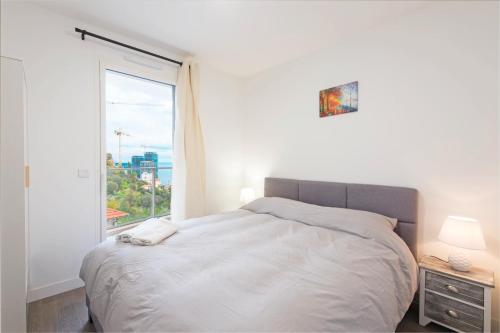 um quarto com uma cama e uma grande janela em Large terrace, sea view, private parking included em Beausoleil