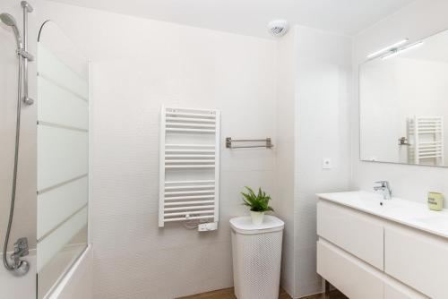 une salle de bain blanche avec des toilettes et un lavabo dans l'établissement Grande terrasse - Vue mer - Parking - BK, à Beausoleil