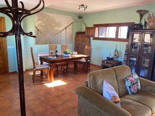 een woonkamer met een bank en een tafel bij Tres Navíos en el Mar Casa Rural de 10 habitaciones con baño individual precios web in Montejo de Tiermes
