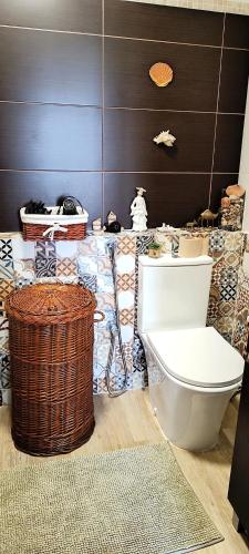 a bathroom with a toilet and a basket at Ricardo Rolão Vista Mar - Edifício Oásis - Bedrooms in Faro