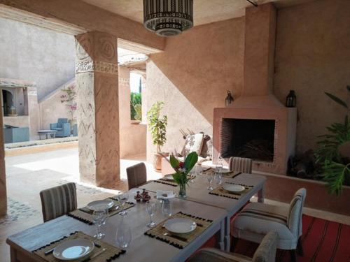 a dining room with a table with chairs and a fireplace at Dar Maha - Amazing villa - pool 15x5M can be heated in Essaouira