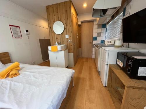 Habitación pequeña con cama y cocina en Rhodes Kagurazaka - Vacation STAY 77334v en Tokio