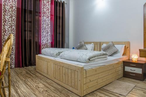 a bedroom with a wooden bed with avertisementatronatronstrationstrationstration at Kasauli Edge Apt with Balcony in Kasauli