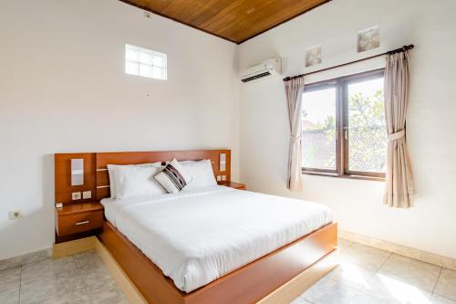 ein Schlafzimmer mit einem Bett und einem Fenster in der Unterkunft Rumah Akira Seminyak in Seminyak