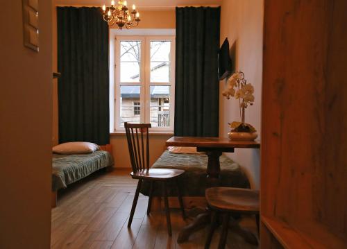 Zimmer mit einem Tisch, einem Bett und einem Fenster in der Unterkunft Sami Swoi Kluki 42 in Kluki