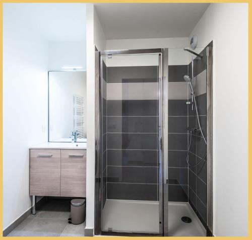 ein Bad mit einer Dusche und einem Waschbecken in der Unterkunft Appartement T2 Sublime Beaumont in Beaumont