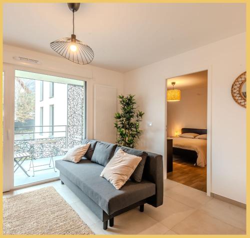 a living room with a couch and a bedroom at Appartement T2 Sublime Beaumont in Beaumont