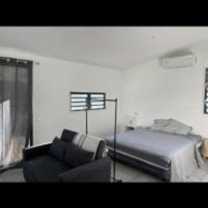 - une chambre avec un lit et un canapé dans l'établissement Tiny House Moorea Haylee, à Papetoai