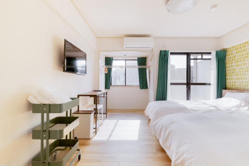 ein Schlafzimmer mit einem großen Bett und einem Fenster in der Unterkunft グランシャーギ in Osaka