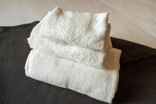 sterta białych ręczników na podłodze w obiekcie Locanda Delle Corse w Rzymie