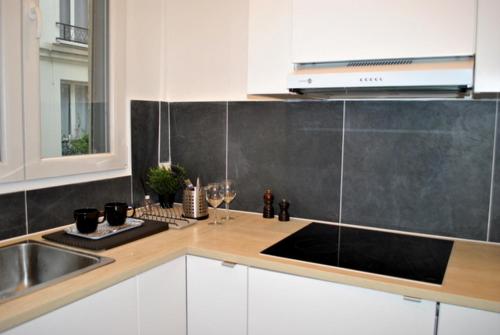 une cuisine avec un évier et un plan de travail dans l'établissement Appartement de 80 m² proche Gare du Nord, à Paris