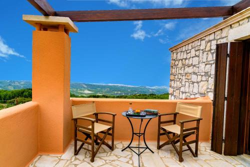 a patio with a table and chairs on a balcony at Villa Fyllosia in Archanes